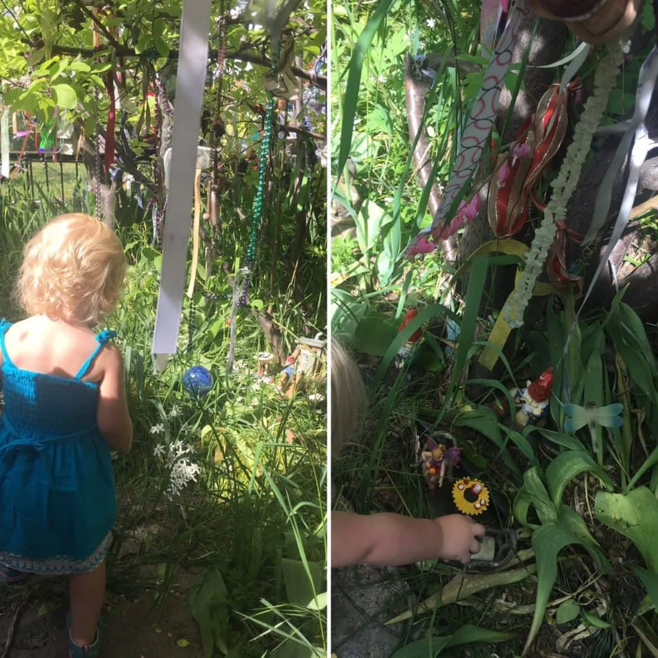 A child exploring a wooded garden hung with ribbons.