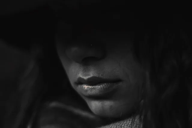 A shadowed black-and-white portrait of a woman.