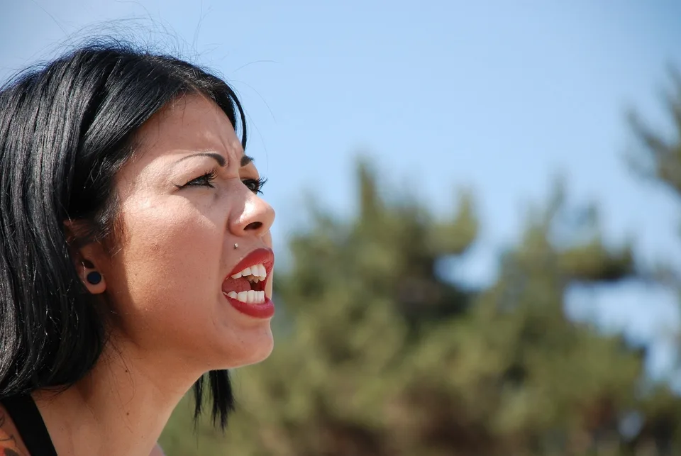 A woman with a determined expression outdoors.