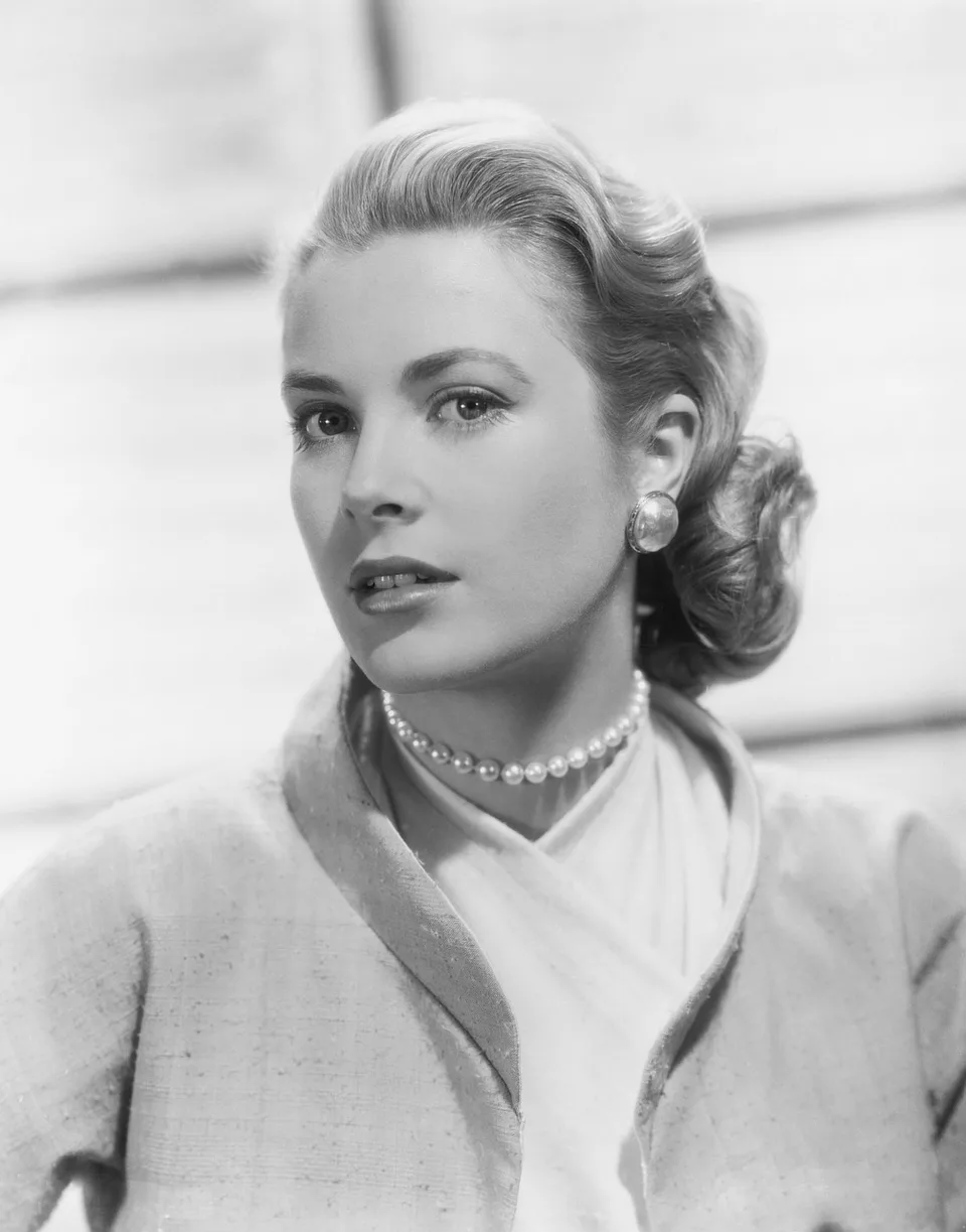 A black-and-white portrait of a woman wearing a necklace.